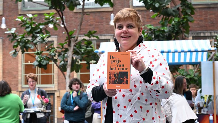 Janine Jansen houdt haar nieuwe boek 'De prijs van het vuur' vast