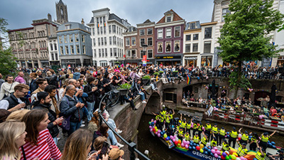 Spectators in Utrecht look at the boat of police officers during the canal parade for Pride month