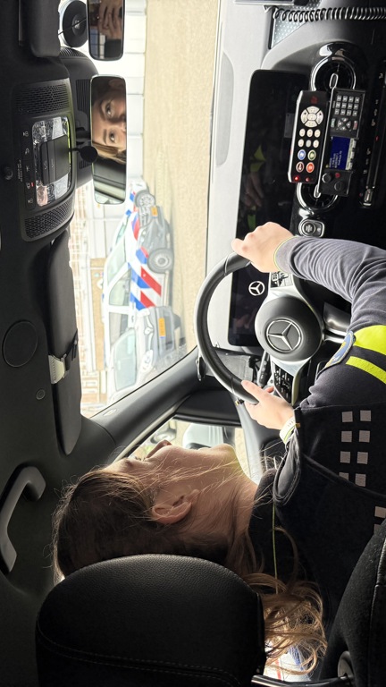 Student Chloë zit achter het stuur van een politieauto