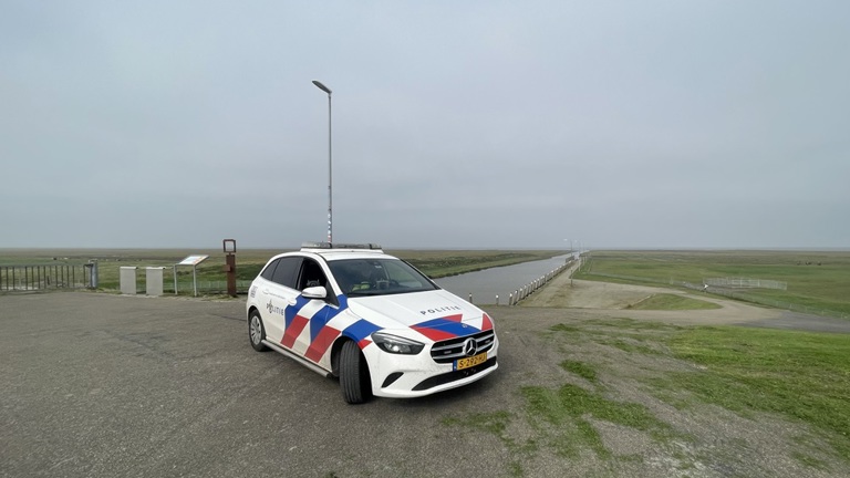 Een politieauto surveilleert in een uitgestrekt gebied van Nederland