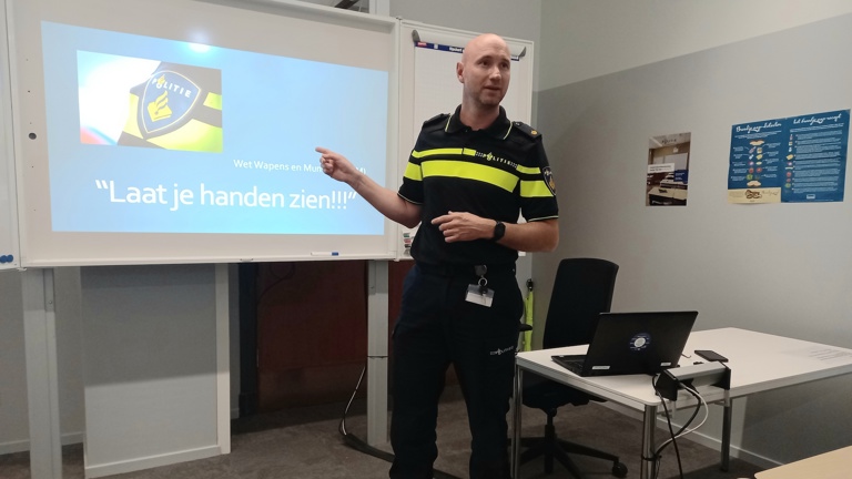 Docent Daniel geeft les in een lokaal en staat voor een digibord