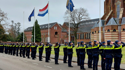 Nieuwe politiestudenten staan in formatie en salueren tijdens hun eerste week op de Politieacademie.