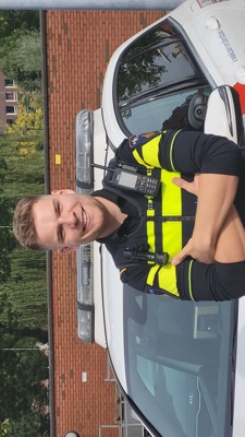 Student Bram staat voor een politieauto