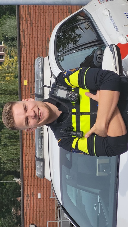 Student Bram staat voor een politieauto