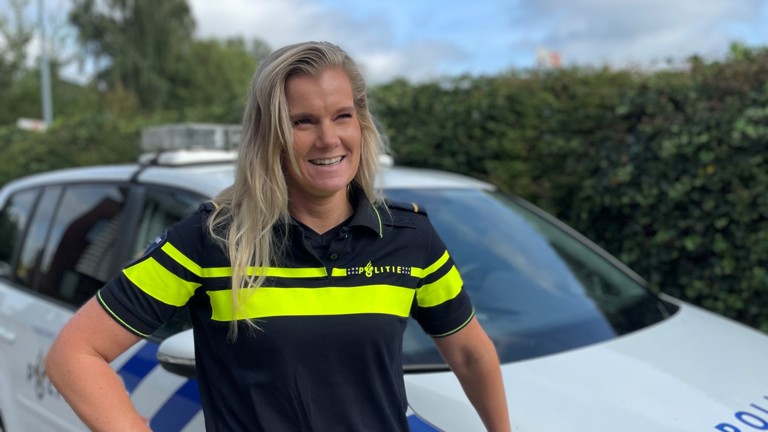 Student Bettine in uniform bij een politieauto