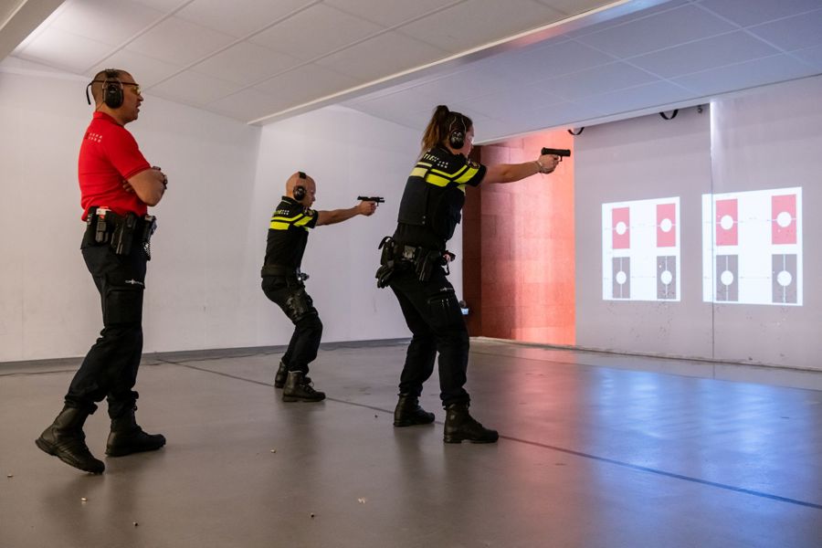 Politieacademie studierichting Toetser - docent helpt studenten bij schietoefening