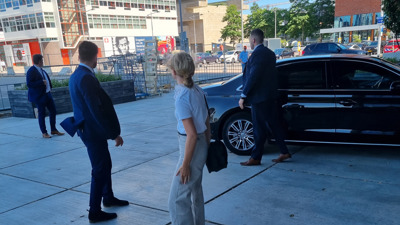 Persoonsbeveiligers Chris en Ramon staan voor een zwarte auto
