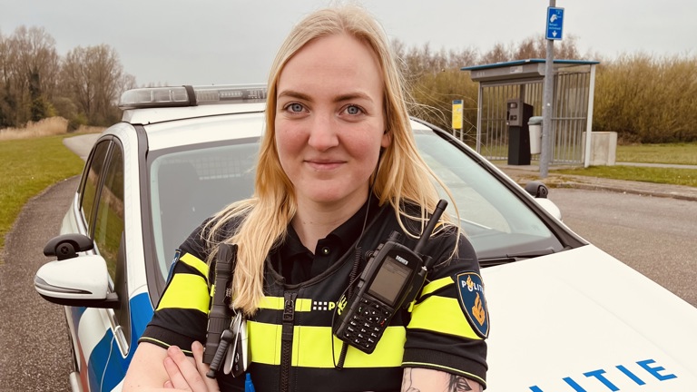 Student Nikki staat bij een politieauto