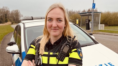 Student Nikki staat bij een politieauto
