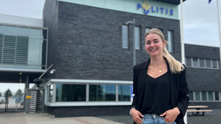 Student Steef staat voor het politiebureau en lacht naar de camera