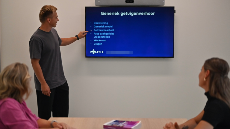 Student Jethro bij een scherm met daarop een presentatie over het generiek getuigenverhoor