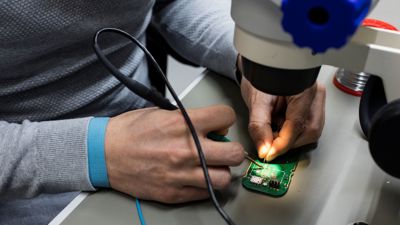 Een techneut werkt aan een mobieltje