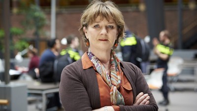 Portret van Kathelijne van Kammen op de Politieacademie in Apeldoorn. Op de achtergrond zijn politiestudenten te zien.