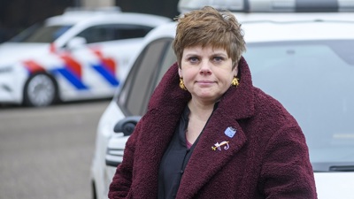 Lector Janine Janssen staat voor een politieauto