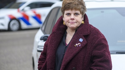 Janine Janssen staat voor een politieauto