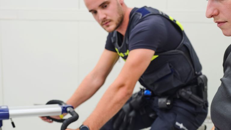 Student Tom zit op een fiets in de klimaatkamer