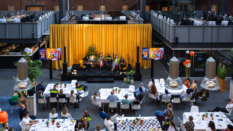 Het atrium op de politieacademie vol bezoekers en politieagenten voor de viering van Ketikoti