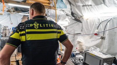 Een beeld van een politieagent die een drugslab inspecteert