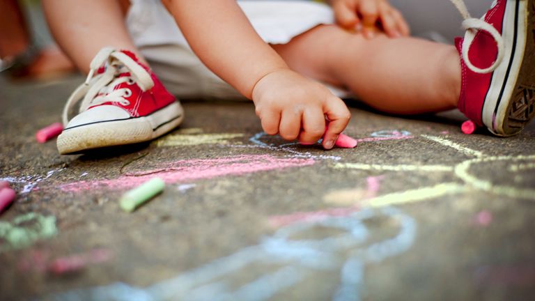 Een jong kind zit op de grond te krijten