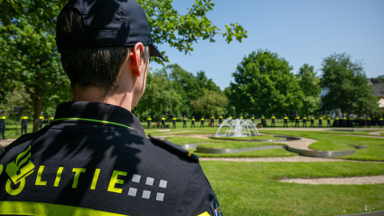 Een politiestudent kijkt uit over de Tuin van Bezinning