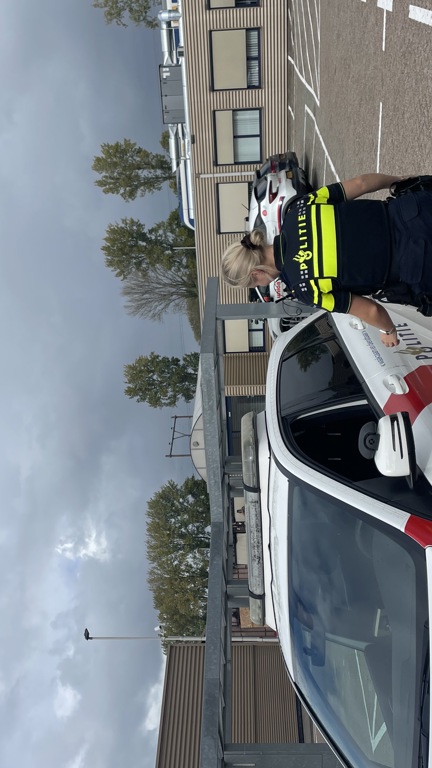 Student Lisa loopt naar een politieauto toe