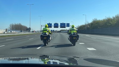 Twee politiemotoren op de snelweg vanuit de auto gezien