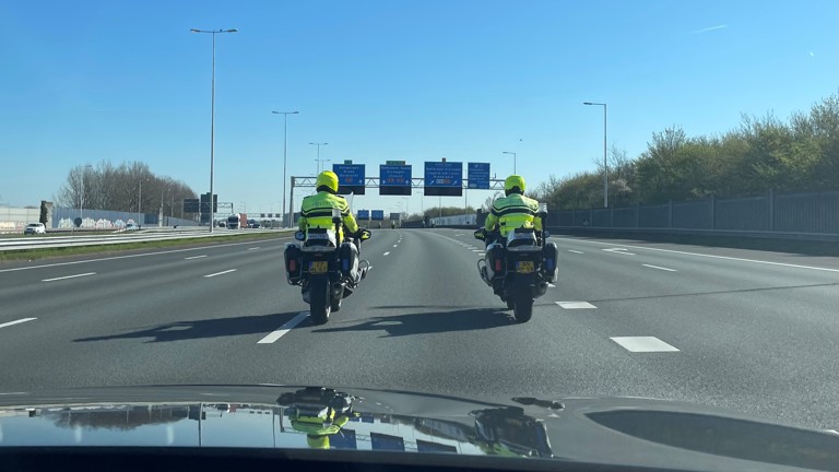 Twee politiemotoren op de snelweg vanuit de auto gezien