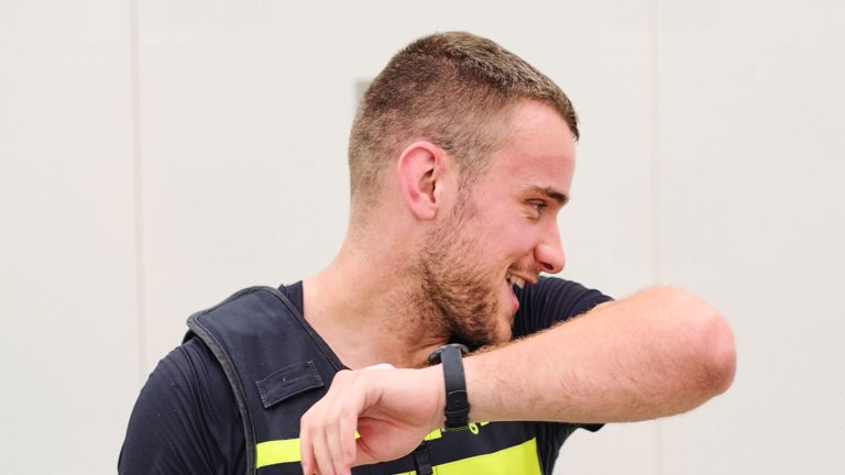 Student Tom veegt het zweet van zijn gezicht af met zijn arm