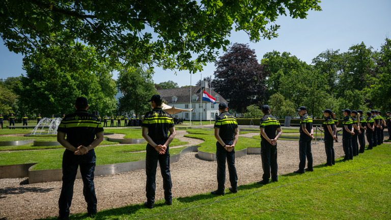 Politiestudenten vormen een erehaag bij het monument Tuin van Bezinning