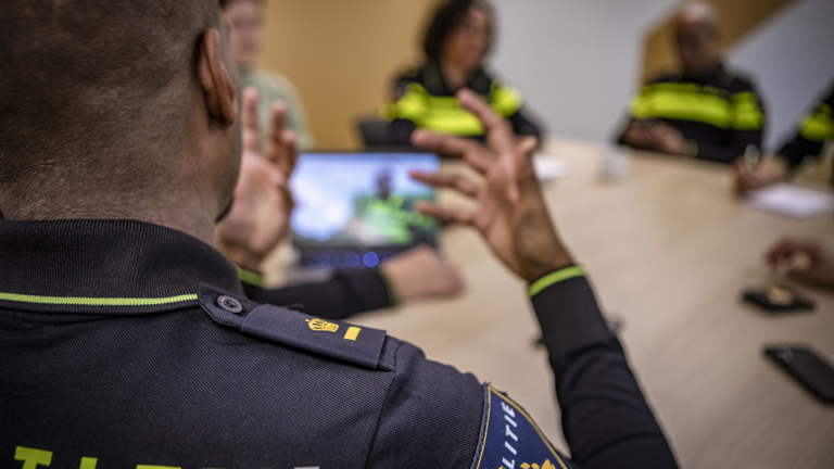 Overleg aan tafel van meerdere politieagenten