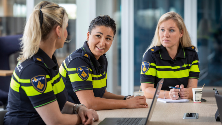 Overleg van verschillende politieagenten aan tafel