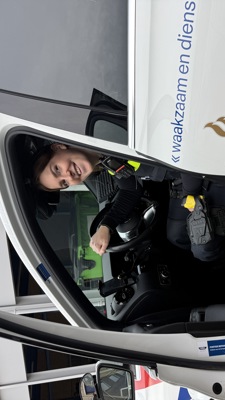 Student Chloë achter het stuur van een politieauto