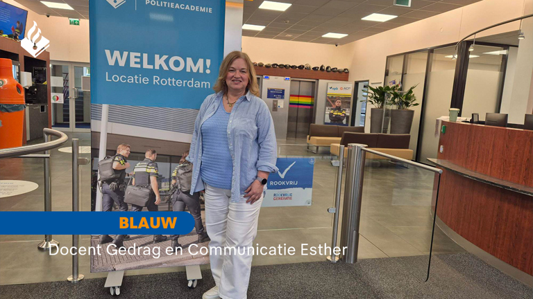Docent Esther staat bij het welkomsbord van de Politieacademie Rotterdam