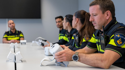 Een student kijkt naar een VR-bril die hij zijn hand heeft