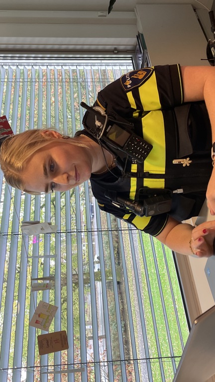 Student Lisa in uniform zit achter een bureau