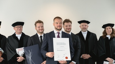 Dimitar Rangelov staat met een getuigschrift in zijn handen tussen andere mensen in