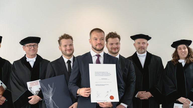 Dimitar Rangelov staat met een getuigschrift in zijn handen tussen andere mensen in