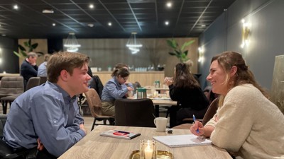 Verhoorstudent Lenny zit aan tafel tegenover een jongen met een verstandelijke beperking